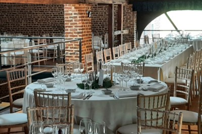 Tente éclairée par des guirlandes lumineuses dans un jardin verdoyant au crépuscule.