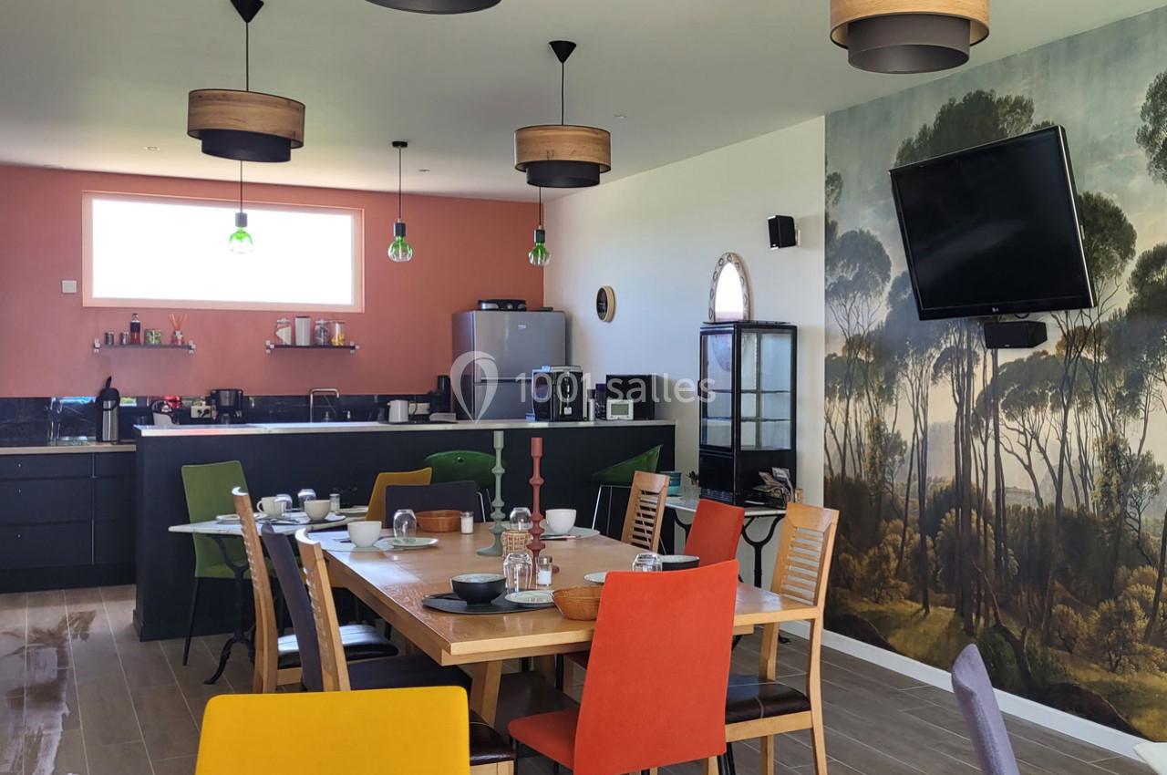 Location salle Bailleau-l'Évêque (Eure-et-Loir) - Le Domaine du Moulin 28 & SPA #35 Salle à manger moderne avec table dressée, chaises colorées, cuisine ouverte et mur décoré d'une fresque forestière.