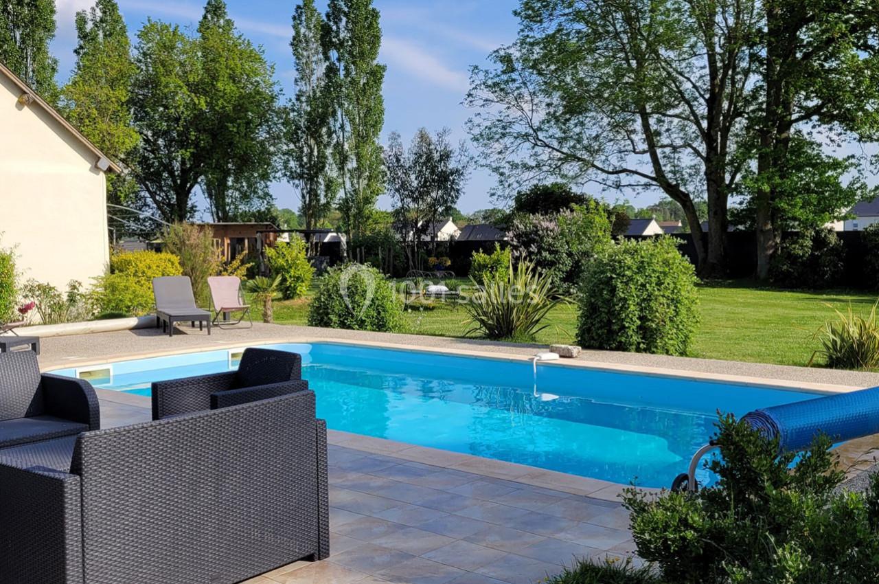 Location salle Bailleau-l'Évêque (Eure-et-Loir) - Le Domaine du Moulin 28 & SPA #8 Piscine extérieure entourée de mobilier de jardin, pelouse et arbres sous un ciel dégagé.