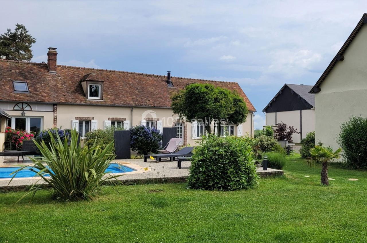 Location salle Bailleau-l'Évêque (Eure-et-Loir) - Le Domaine du Moulin 28 & SPA #2 Maison traditionnelle avec piscine, terrasse aménagée et jardin verdoyant sous un ciel partiellement nuageux.