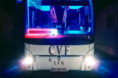 Miniature CVF Transport #2 Intérieur d'un autocar avec sièges rouges, éclairage tamisé et allée centrale recouverte d'un tapis rouge.