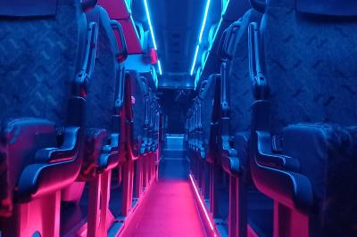 Miniature CVF Transport #4 Intérieur d'un autocar avec sièges rouges, éclairage tamisé et allée centrale recouverte d'un tapis rouge.