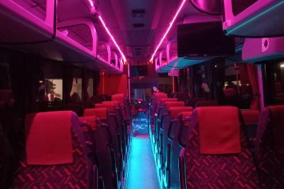 Miniature CVF Transport #5 Intérieur d'un autocar avec sièges rouges, éclairage tamisé et allée centrale recouverte d'un tapis rouge.