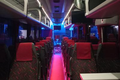 Miniature CVF Transport #7 Intérieur d'un autocar avec sièges rouges, éclairage tamisé et allée centrale recouverte d'un tapis rouge.