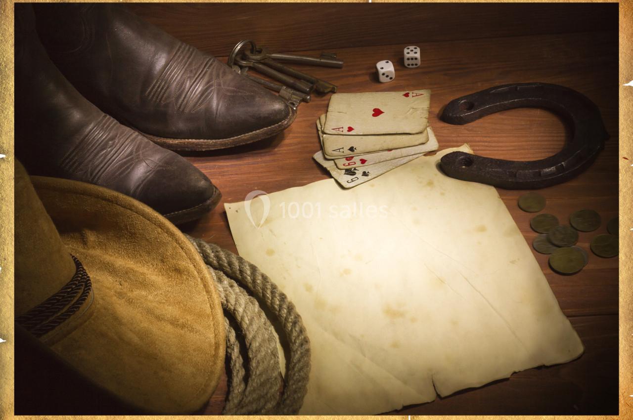 Affiche avec bottes, chapeau, fer à cheval, dés, cartes et pièce de papier évoquant un thème western.