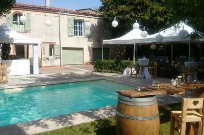 Vieille tour en briques rouges avec des fenêtres, entourée de végétation et d'un ciel bleu clair.
