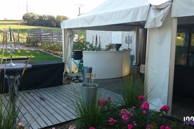 Vieille tour en briques rouges avec des fenêtres, entourée de végétation et d'un ciel bleu clair.