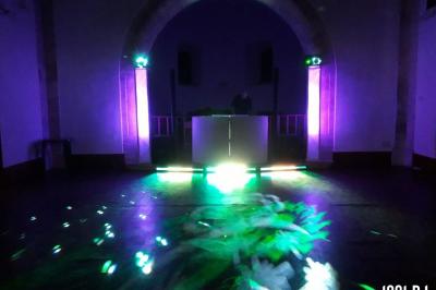 Vieille tour en briques rouges avec des fenêtres, entourée de végétation et d'un ciel bleu clair.