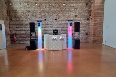 Vieille tour en briques rouges avec des fenêtres, entourée de végétation et d'un ciel bleu clair.