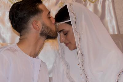 Miniature CAMELIA ET TAREK BENATIA Une mariée glisse une alliance au doigt de son partenaire lors d'une cérémonie de mariage.