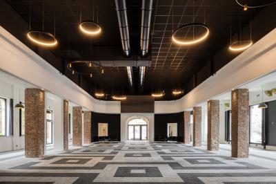 Façade moderne d'un hôtel Mercure avec des voitures circulant devant, entouré d'arbres et d'un ciel partiellement nuageux.