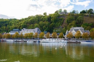Miniature Location salle Namur (Province de Namur) - Casino Resort Namur #29 Vue sur une rivière bordée de bateaux, avec des bâtiments historiques et une colline boisée en arrière-plan.