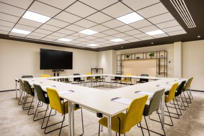 Miniature Location salle Namur (Namur) - Casino Resort Namur #4 Terrasse moderne avec mobilier vert et blanc, vue sur une rivière et des bâtiments en arrière-plan.