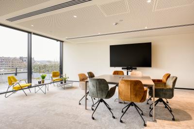 Miniature Location salle Namur (Namur) - Casino Resort Namur #10 Terrasse moderne avec mobilier vert et blanc, vue sur une rivière et des bâtiments en arrière-plan.