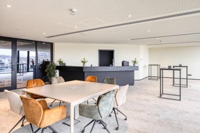 Miniature Location salle Namur (Namur) - Casino Resort Namur #11 Terrasse moderne avec mobilier vert et blanc, vue sur une rivière et des bâtiments en arrière-plan.