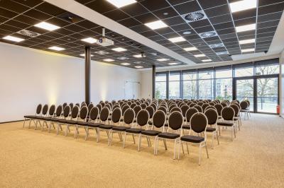 Miniature Location salle Namur (Namur) - Casino Resort Namur #12 Terrasse moderne avec mobilier vert et blanc, vue sur une rivière et des bâtiments en arrière-plan.