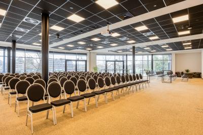 Miniature Location salle Namur (Namur) - Casino Resort Namur #21 Terrasse moderne avec mobilier vert et blanc, vue sur une rivière et des bâtiments en arrière-plan.