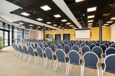 Miniature Location salle Namur (Namur) - Casino Resort Namur #24 Terrasse moderne avec mobilier vert et blanc, vue sur une rivière et des bâtiments en arrière-plan.