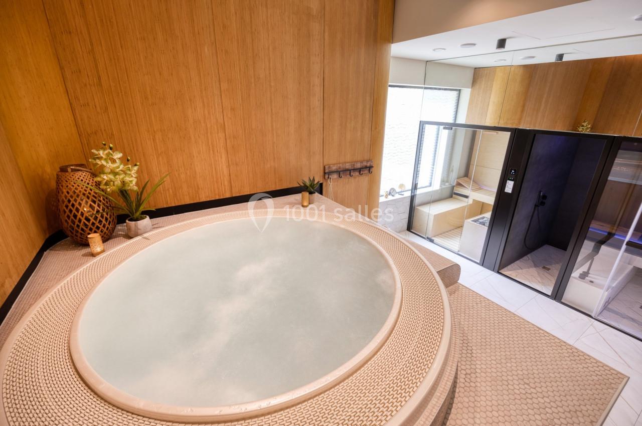 Location salle Namur (Namur) - Casino Resort Namur #36 Bain à remous dans une pièce en bois clair avec une douche et un sauna vitré en arrière-plan.