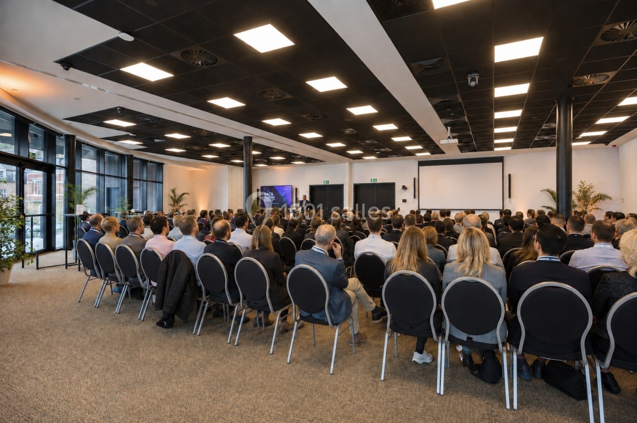 Location salle Namur (Province de Namur) - Casino Resort Namur #16 Salle de conférence avec un public assis face à un orateur et un écran de présentation.
