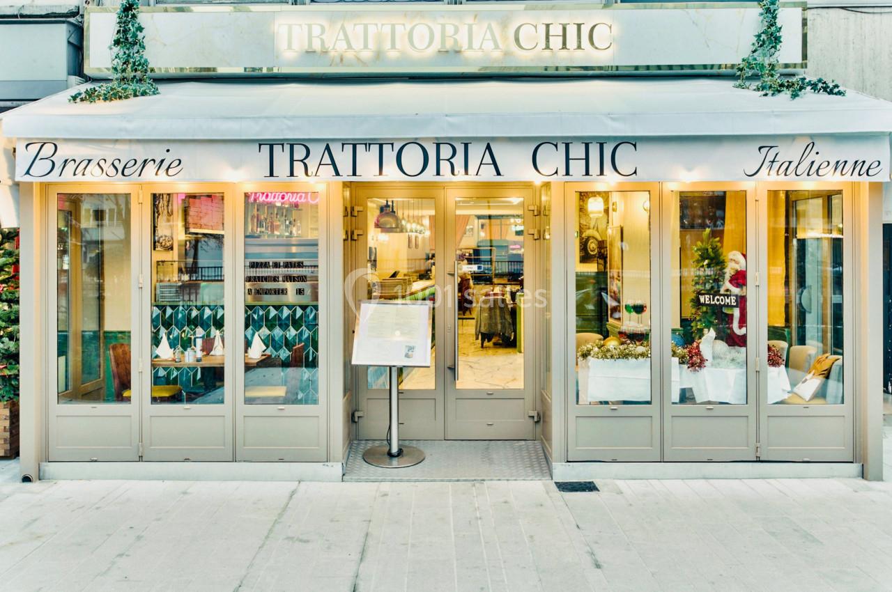 Façade d'un restaurant italien avec terrasse couverte, enseigne ’Trattoria Chic’ et menu affiché à l'entrée.