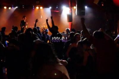 Miniature DJ Asnières-sur-Seine (Hauts-de-Seine) - Inji Events #9 Un DJ mixe sur scène devant un écran géant projetant une vidéo d'une danseuse en tenue scintillante.