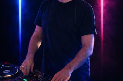 Miniature DJ Asnières-sur-Seine (Hauts-de-Seine) - Inji Events #2 Un DJ mixe sur scène devant un écran géant projetant une vidéo d'une danseuse en tenue scintillante.