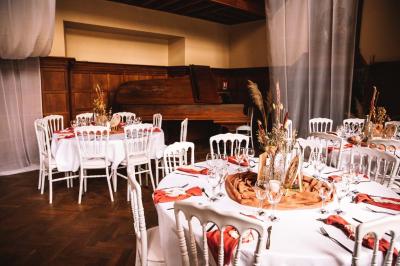 Miniature Location salle Bellignies (Nord) - Château de Bellignies #4 Salle de réception élégante avec tables dressées, chaises blanches, décorations florales et un piano en arrière-plan.