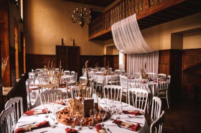 Miniature Location salle Bellignies (Nord) - Château de Bellignies #2 Salle de réception élégante avec tables dressées, chaises blanches, décorations florales et un piano en arrière-plan.