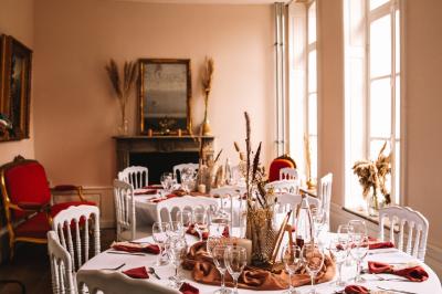 Miniature Location salle Bellignies (Nord) - Château de Bellignies #5 Salle de réception élégante avec tables dressées, chaises blanches, décorations florales et un piano en arrière-plan.
