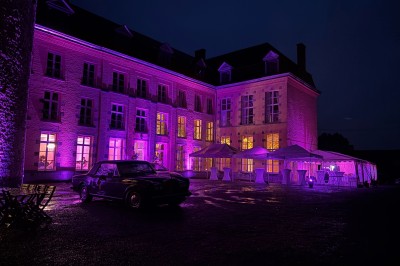 Miniature Location salle Bellignies (Nord) - Château de Bellignies #59 Salle de réception élégante avec tables dressées, chaises blanches, décorations florales et un piano en arrière-plan.