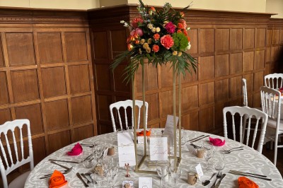 Miniature Location salle Bellignies (Nord) - Château de Bellignies #62 Salle de réception élégante avec tables dressées, chaises blanches, décorations florales et un piano en arrière-plan.