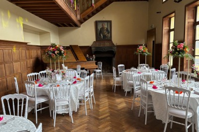 Miniature Location salle Bellignies (Nord) - Château de Bellignies #66 Salle de réception élégante avec tables dressées, chaises blanches, décorations florales et un piano en arrière-plan.