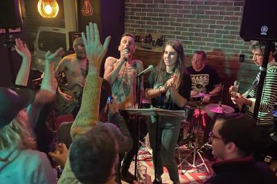 Miniature Location salle Lille (Nord) - Barnett's #7 Deux personnes souriantes dans un café à l'ambiance chaleureuse, avec un mur en briques et une enseigne néon.