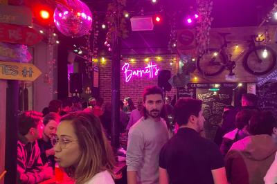 Miniature Location salle Lille (Nord) - Barnett's #2 Deux personnes souriantes dans un café à l'ambiance chaleureuse, avec un mur en briques et une enseigne néon.