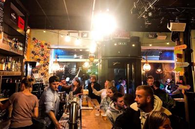 Miniature Location salle Lille (Nord) - Barnett's #5 Deux personnes souriantes dans un café à l'ambiance chaleureuse, avec un mur en briques et une enseigne néon.