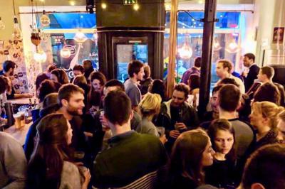 Miniature Location salle Lille (Nord) - Barnett's #6 Deux personnes souriantes dans un café à l'ambiance chaleureuse, avec un mur en briques et une enseigne néon.