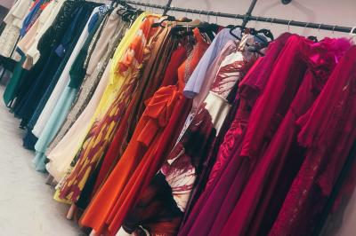 Femme souriante portant une jupe argentée scintillante et une chemise blanche, debout sur une structure métallique en…