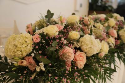 Miniature Location salle Noisy-le-Grand (Seine-Saint-Denis) - Espace du Mont d'Est #8 Centre de table floral avec roses et feuillage, entouré de tables dressées dans une salle lumineuse.