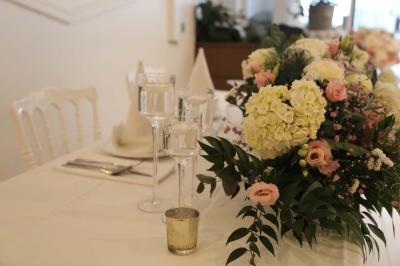 Miniature Location salle Noisy-le-Grand (Seine-Saint-Denis) - Espace du Mont d'Est #7 Centre de table floral avec roses et feuillage, entouré de tables dressées dans une salle lumineuse.