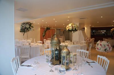 Miniature Location salle Noisy-le-Grand (Seine-Saint-Denis) - Espace du Mont d'Est #12 Centre de table floral avec roses et feuillage, entouré de tables dressées dans une salle lumineuse.