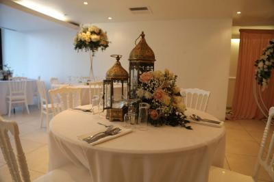 Miniature Location salle Noisy-le-Grand (Seine-Saint-Denis) - Espace du Mont d'Est #13 Centre de table floral avec roses et feuillage, entouré de tables dressées dans une salle lumineuse.