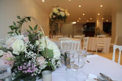 Miniature Location salle Noisy-le-Grand (Seine-Saint-Denis) - Espace du Mont d'Est #16 Centre de table floral avec roses et feuillage, entouré de tables dressées dans une salle lumineuse.