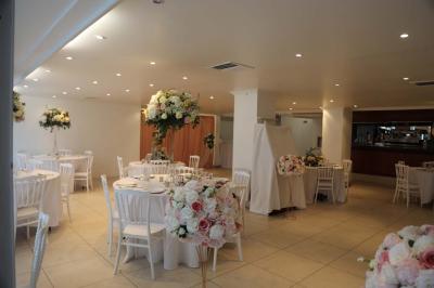 Miniature Location salle Noisy-le-Grand (Seine-Saint-Denis) - Espace du Mont d'Est #18 Centre de table floral avec roses et feuillage, entouré de tables dressées dans une salle lumineuse.