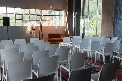 Miniature La salle panoramique Salle lumineuse avec de grandes baies vitrées, tables dressées avec nappes grises, vaisselle et décoration florale.