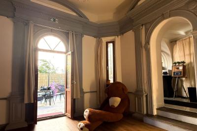 Cuisine moderne avec îlot central noir, chaises hautes, meubles rouges, électroménagers intégrés et carrelage blanc.