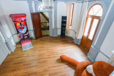 Cuisine moderne avec îlot central noir, chaises hautes, meubles rouges, électroménagers intégrés et carrelage blanc.