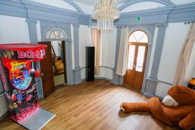 Cuisine moderne avec îlot central noir, chaises hautes, meubles rouges, électroménagers intégrés et carrelage blanc.