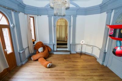 Cuisine moderne avec îlot central noir, chaises hautes, meubles rouges, électroménagers intégrés et carrelage blanc.