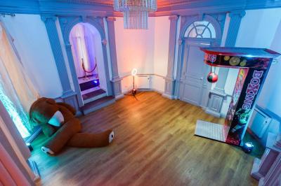 Cuisine moderne avec îlot central noir, chaises hautes, meubles rouges, électroménagers intégrés et carrelage blanc.